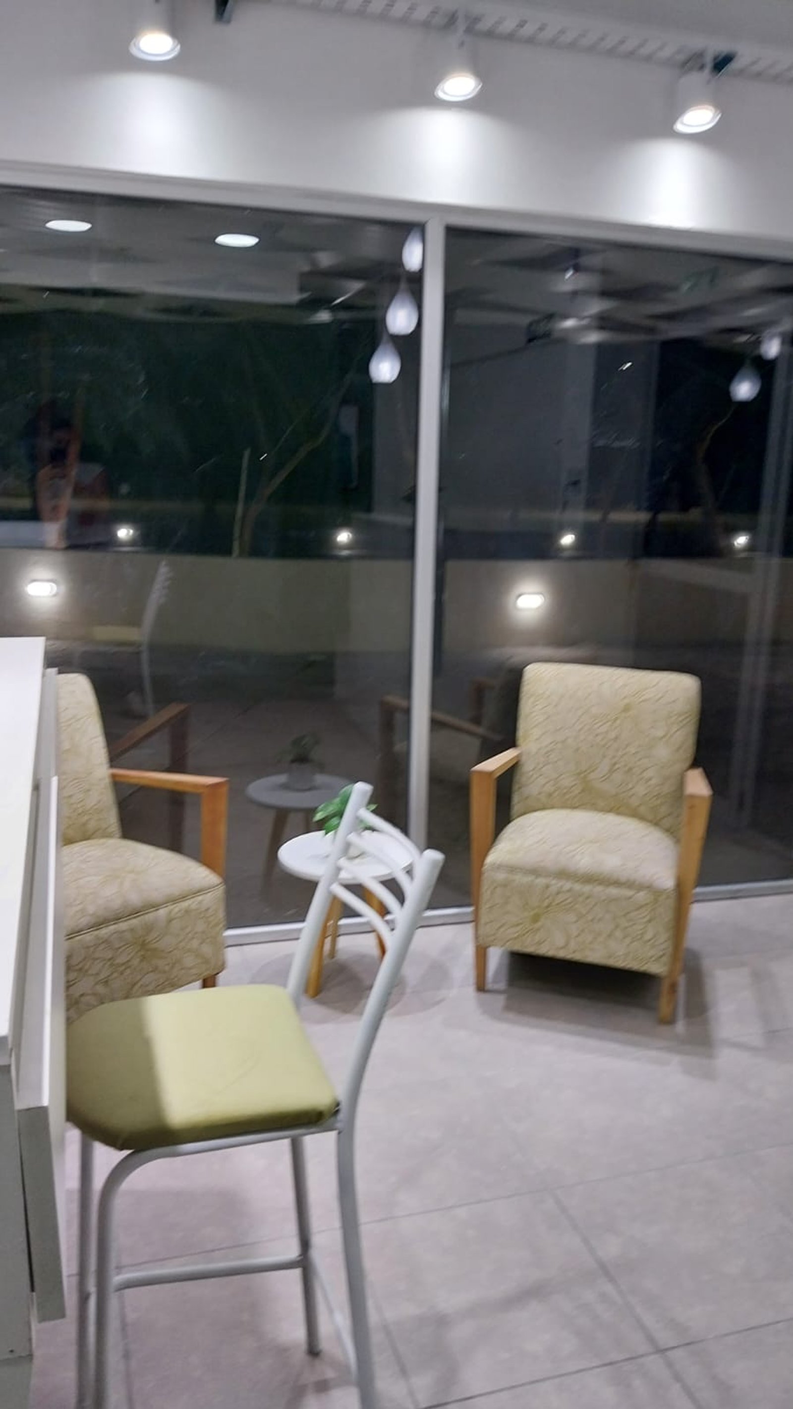 Sala de estar exterior con sillones y silla moderna — proyecto BC ESTETICA , por Yamil Cerna, en San Martín